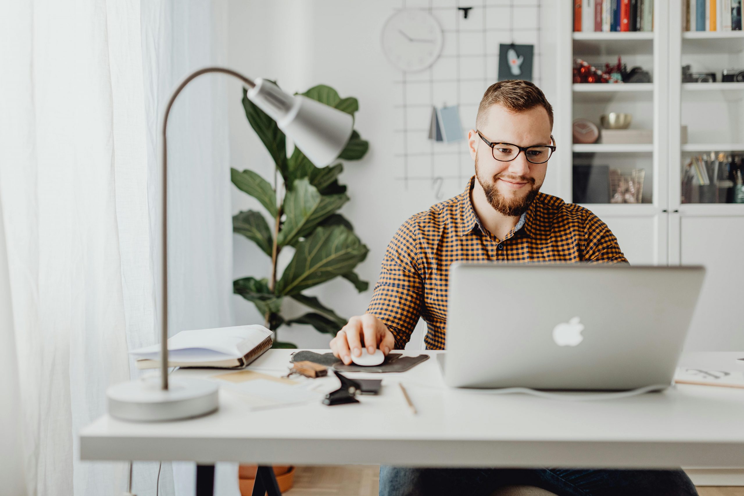man using a MacBook at his desk